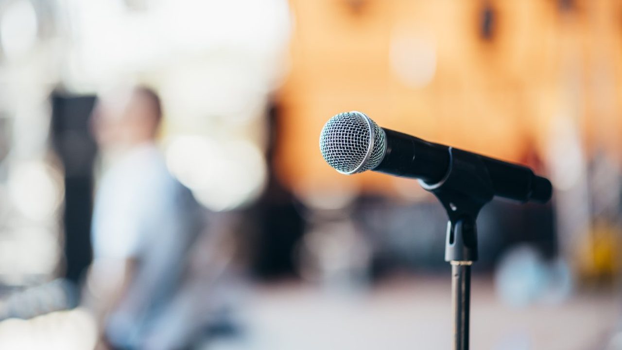 A microphone on a stand at a warmly lit event